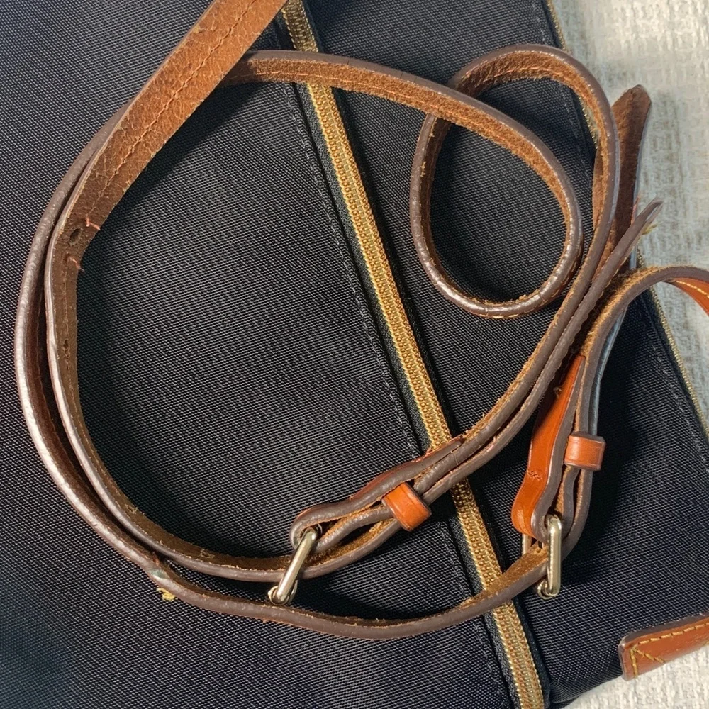 Dooney & Bourke black nylon crossbody bag with brown leather strap and accents